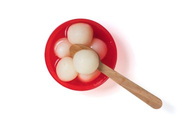 Geleneksel Hint tatlısı Rasgulla beyaz arka planda tahta kaşıkla kırmızı bir kasede servis yapıyordu..