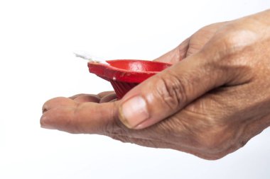 An elderly woman hand holding a red candle on a white background, with a clean clipping path. Ideal for designs focused on tradition and hope. clipart