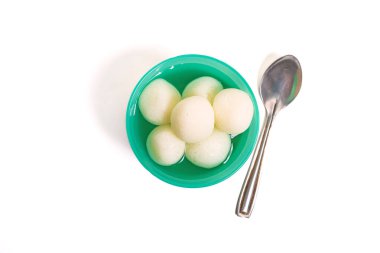 Gümüş kaşıkla servis edilen yeşil plastik bir kasede servis edilen geleneksel Hint rasgulla manzarası. Hint şenlik tasarımları için ideal..