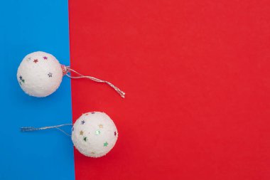 Canlı kırmızı ve mavi bir arkaplanda dekoratif Noel süslemeleri, Noel temaları, mevsimsel kutlamalar ve yaratıcı tasarımlar için mükemmel..