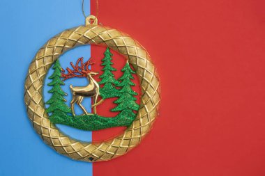 Festive golden ornament featuring reindeer and trees, highlighting holiday themes on vivid red-blue background. Perfect for seasonal celebrations or christmas decorative purposes. clipart