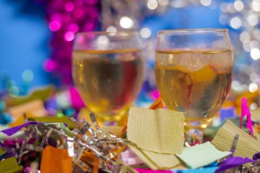 Two glasses of sparkling beverage surrounded by vibrant colored confetti and shiny streamers. Perfect for use in event promotions, social media content, and festive designs. clipart