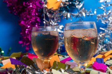 Two glasses of sparkling beverage surrounded by vibrant colored confetti and shiny streamers. Perfect for use in event promotions, social media content, and festive designs. clipart