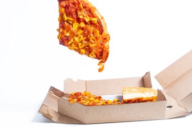 A close-up shot of a slice of pizza topped with vibrant yellow corn being lifted from a cardboard box. Perfect for food advertisements, delivery promotions clipart