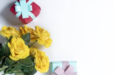 Sarı güllerin üst görüntüsü ve beyaz bir arka planda paketlenmiş hediye kutuları aşkı kutlamak için mükemmel..