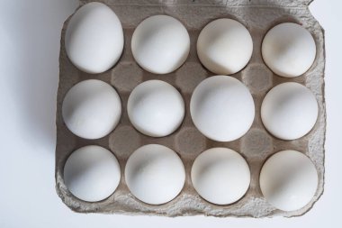 Kartondan yumurta kutusuna düzinelerce beyaz yumurta istiflenmiş, izole edilmiş. Yemek, yemek, market, kümes hayvanları, beslenme, tazelik gibi kavramlar için uygundur..