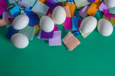 Top view of brightly decorated Easter eggs on a multi-colored crepe paper background. clipart