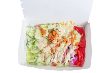 Salatalık, domates ve kremalı marul da dahil olmak üzere paket servis edilen yeni hazırlanmış bir salata sağlıklı ve besleyici bir yemek seçeneği sunuyor..