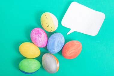 Boş konuşma balonlu canlı Paskalya yumurtaları, kişisel mesajlar veya tasarımlar için parlak yeşil bir arka plana yerleştirilir..