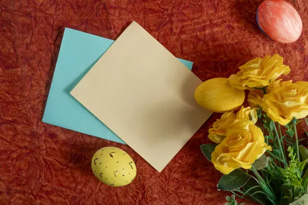 Parlak sarı güller, boyanmış Paskalya yumurtaları ve renkli kağıt kaplamalar şenlikli bir zemin oluşturur. Paskalya bayramını kutlamak ve neşeli bir ortam yaratmak için mükemmel..