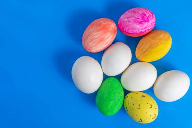 Paskalya yumurtaları mavi arka planda yaratıcı bir şekilde sergilenir. Kutlama, bahar ve kültür mirası temaları için mükemmel..