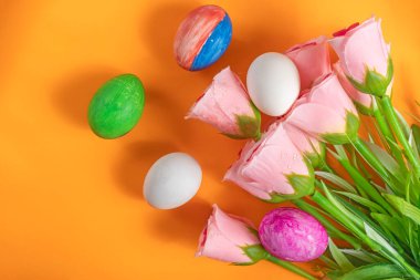 Pembe laleler ve elle boyanmış Paskalya yumurtaları ile canlı bir dekoratif sahne mevsimsel kutlamaları çağrıştırıyor..
