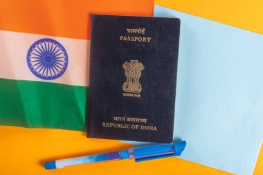 Ulusal bayrak ve ofis malzemeleriyle birlikte bir Hint pasaportu sergileniyor. seyahat kavramı