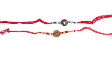 Beyaz arka planda, kardeşçe sevgi ve kültür mirasını sembolize eden iki güzel dizayn edilmiş rakhis gösteriliyor. Raksha Bandhan için uygun..