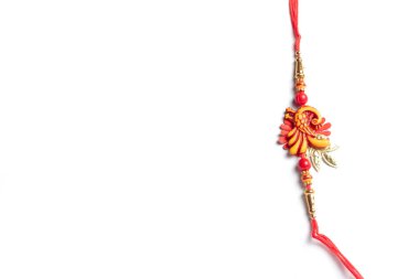 Raksha Bandhan 'ın geleneksel Hint festivalini temsil eden renkli bir Rakhi nişanı. Beyaz bir arka planda izole edilmiş, karmaşık detayları ve neşeli kültürel önemi vurguluyor..