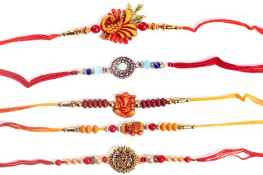 Canlı Rakhi bilezikleri, kırmızı, turuncu ve altın renkli boncuklar, tılsımlar ve parlak iplikler. Hint festivalleri ve aile hediyeleri için mükemmel. Bu dekoratif bilezikler koruma, sevgi ve birliği simgeliyor..
