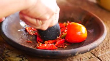 Ölümlü ve tokmakla sambal yapmak. Sambal: Sambal, Endonezya 'da kullanılan bir acı biber sosudur. Tipik olarak çeşitli biber karışımından ve ikincil malzemelerden yapılır.. 
