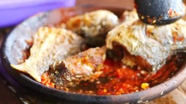 Ölümlü ve tokmakla sambal yapmak. Sambal: Sambal, Endonezya 'da kullanılan bir acı biber sosudur. Tipik olarak çeşitli biber karışımından ve ikincil malzemelerden yapılır.. 