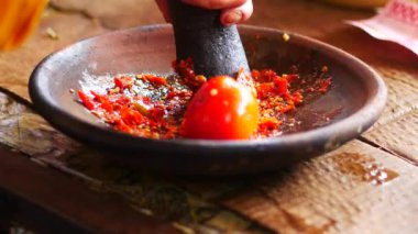 Ölümlü ve tokmakla sambal yapmak. Sambal: Sambal, Endonezya 'da kullanılan bir acı biber sosudur. Tipik olarak çeşitli biber karışımından ve ikincil malzemelerden yapılır.. 