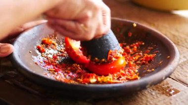 Ölümlü ve tokmakla sambal yapmak. Sambal: Sambal, Endonezya 'da kullanılan bir acı biber sosudur. Tipik olarak çeşitli biber karışımından ve ikincil malzemelerden yapılır.. 