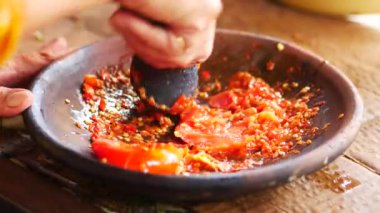 Ölümlü ve tokmakla sambal yapmak. Sambal: Sambal, Endonezya 'da kullanılan bir acı biber sosudur. Tipik olarak çeşitli biber karışımından ve ikincil malzemelerden yapılır.. 