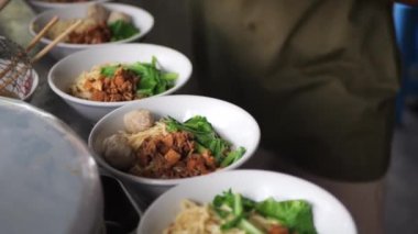 Şefin tavada yaptığı acılı sebze ve kızarmış etle Aceh eriştesi pişirmek. Yemek tarifi konseptini kapat.