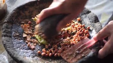Rujak petisi hazırlamak. Rujak petisi, Java 'nın buharda pişirilmiş sebzelerden, kızarmış sarımsak, acı biber, petis (mayalanmış karides ezmesi) ve yer fıstığından yapılan geleneksel yemektir.