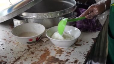 Tavuk lapası satıcısı ya da tukang bubur ayam müşteriler ya da pelangganlar için yemeğini hazırlar. Bubur Ayam (Tavuk Lapası), Malezya Geleneksel Yemeği tuzlu yumurtalı beyaz pirinç lapasından oluşur, 