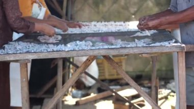 Endonezyalı işçiler güneşte kurutulmak üzere balık düzenliyor, ince tuzlanmış balıklara dönüştürülüyor.