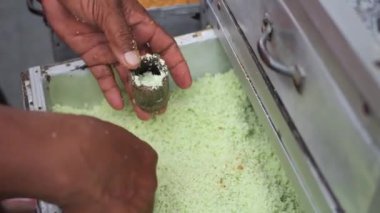 Geleneksel Endonezya yemek tezgahı yapma süreci, kue putu bambu. Pirinç unundan yapılmış ve bambu kalıpları kullanılarak oluşturulmuş. Yemek pişirme ve pandan aromasının ıslık sesi çok belirgindir..