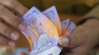 Tarakan, Endonezya .10032022: İş adamlarına yakın çekim elde para sayar. İş adamlarına yakın olmak rupiah 'ı ellerinde tutar..