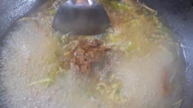 Şefin tavada yaptığı acılı sebze ve kızarmış etle Aceh eriştesi pişirmek. Yemek tarifi konseptini kapat.