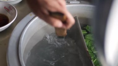 Tavuklu erişte hazırlıyorum. Penjual mie ayam bakso ya da alıcıya tavuklu erişte yapan köfteli tavuklu erişte satıcısı manzarası. Seçici odak. 