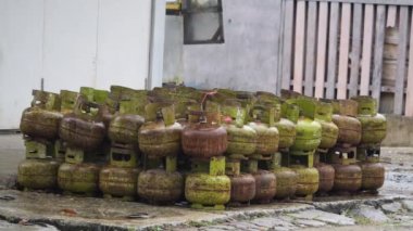 Boş elpigi tüpleri yığını. Bu mini gaz silindiri kavun gibi yeşil renkli yuvarlak bir şekle sahiptir. Bu tüp 3 kg ağırlığındayken, bunun toplam ağırlığı 6 kg..