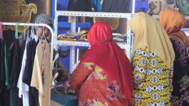 Tarakan, Endonezya. 25 2022: Endonezyalı bir Müslüman kadın Tarakan Endonezya 'daki Au yang dalam bahasa inggris lebih dikenal sebagai Small ve Medium Enterprise ürünleri sergisinde ürün seçiyor.