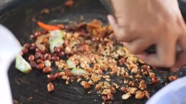 Rujak petisi hazırlamak. Rujak petisi, Java 'nın buharda pişirilmiş sebzelerden, kızarmış sarımsak, acı biber, petis (mayalanmış karides ezmesi) ve yer fıstığından yapılan geleneksel yemektir.