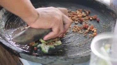 Rujak petisi hazırlamak. Rujak petisi, Java 'nın buharda pişirilmiş sebzelerden, kızarmış sarımsak, acı biber, petis (mayalanmış karides ezmesi) ve yer fıstığından yapılan geleneksel yemektir.