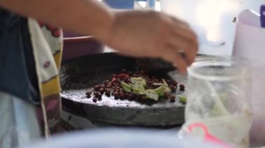 Rujak petisi hazırlamak. Rujak petisi, Java 'nın buharda pişirilmiş sebzelerden, kızarmış sarımsak, acı biber, petis (mayalanmış karides ezmesi) ve yer fıstığından yapılan geleneksel yemektir.