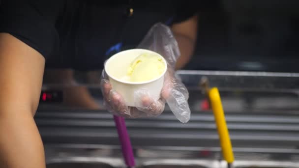 女手端着勺子从冰箱里取出冰淇淋 放在杯子里吃 女人吃了一勺美味的冰淇淋 冰箱加冰淇淋 女人在冰淇淋店工作 — 图库视频影像