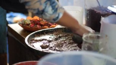 Rujak petisi hazırlamak. Rujak petisi, Java 'nın buharda pişirilmiş sebzelerden, kızarmış sarımsak, acı biber, petis (mayalanmış karides ezmesi) ve yer fıstığından yapılan geleneksel yemektir.