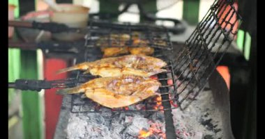 Balık pişirme konusunda seçici bir odaklanma. Izgarada marine edilmiş balık pişirme ve kızartma. Thunnini kömür üstünde ızgara yaptı. Yaz barbeküsü el salamura balık