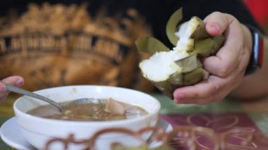 Coto Makassar Geleneksel Et Çorbası içiyorum. Coto Makassar, Güney Sulawesi, Makassar 'dan geleneksel yemek. Biftekle karıştırılmış sığır sakatatından yapılır, özel formüle edilmiş baharatlarla tatlandırılır..