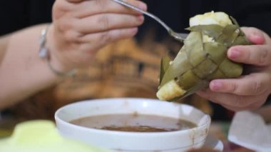 Coto Makassar Geleneksel Et Çorbası içiyorum. Coto Makassar, Güney Sulawesi, Makassar 'dan geleneksel yemek. Biftekle karıştırılmış sığır sakatatından yapılır, özel formüle edilmiş baharatlarla tatlandırılır..