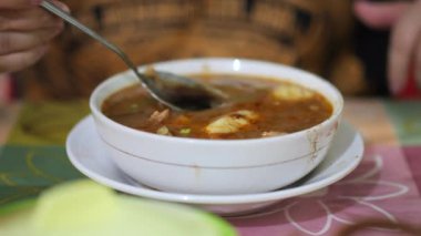 Coto Makassar Geleneksel Et Çorbası içiyorum. Coto Makassar, Güney Sulawesi, Makassar 'dan geleneksel yemek. Biftekle karıştırılmış sığır sakatatından yapılır, özel formüle edilmiş baharatlarla tatlandırılır..