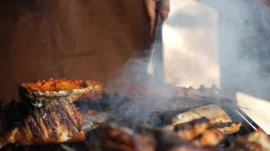 Balık pişirirken yakın çekim. Izgarada marine edilmiş balık pişirme ve kızartma. Kömürün üzerinde ızgara yapılmış deniz balığı. Ikan bakar. Seçici odak.