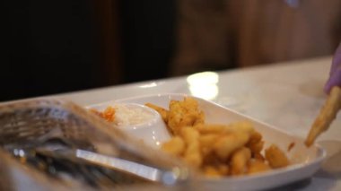 Kızarmış patatesleri kırmızı sosa bandırmak, yakın plan.