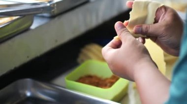 Bir Endonezyalı sokak satıcısı tavada pisang molen (kızarmış muzlu hamur işi) hazırlıyor. Endonezya mezesi pisang molen (kızarmış muzlu hamur işi).