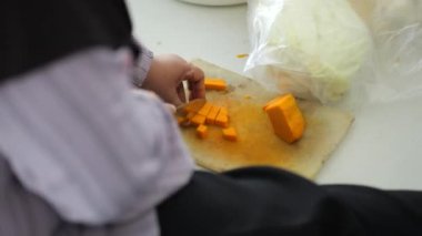 Endonezyalı yaşlı bir kadının elleri, Endonezya, Tarakan 'da düzenlenen ortak yemek etkinliği sırasında balkabağı kesiyor.