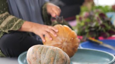 Endonezyalı yaşlı bir kadının elleri, Endonezya, Tarakan 'da düzenlenen ortak yemek etkinliği sırasında balkabağı kesiyor.