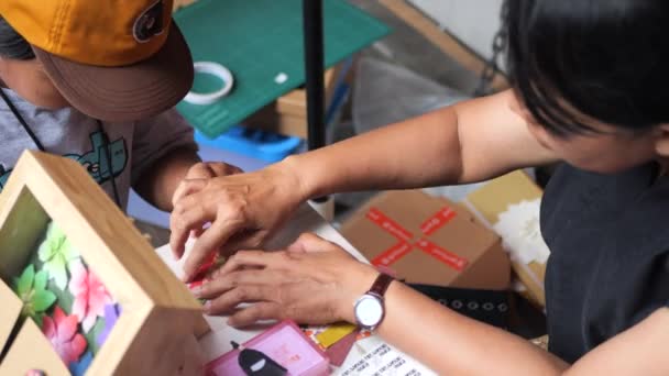 一名印度尼西亚女教师和一名小男孩用纸做折纸工艺品 — 图库视频影像